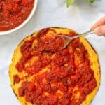 pizza sauce topped on a pizza base
