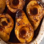 a closeup view of these delicious baked spiced pears coated in a rich sauce.