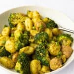 Image shows a close up of Sausage Pesto Gnocchi served in a bowl with a white background.