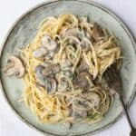 Vegan Mushroom Pasta served on a blue plate with a silver fork