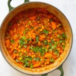 Chickpea stew in a large pot displayed on white bakcground