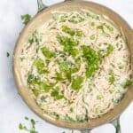 spaghetti carbonara in large frying pan topped with freshly chopped parsley