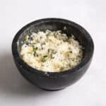pot of rosemary salt in black pot on white surface.