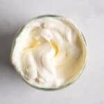 homemade vegan mayonnaise in a jar served on a white background.