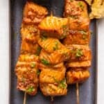 Asian salmon skewers on a plate.