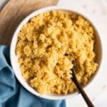 quinoa in a white bowl with a spoon.