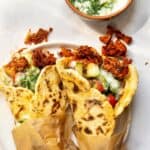 Two vegan gyros served on a plate.