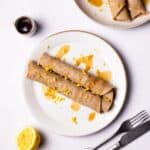 Gluten Free Crepes on a plate drizzled with maple syrup.