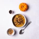 Pumpkin Oatmeal served in a bowl, topped with walnuts and pumpkin seeds.