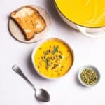 Butternut Squash Soup served with toast and pumpkin seeds.