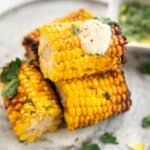 Air fryer corn on the cob served with cream on top.