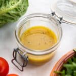 dressing with maple syrup and dijon mustard in a glass jar.