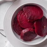 Pickled beetroot served on a white plate.