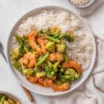 prawn stir fry served on a white plate with white rice.