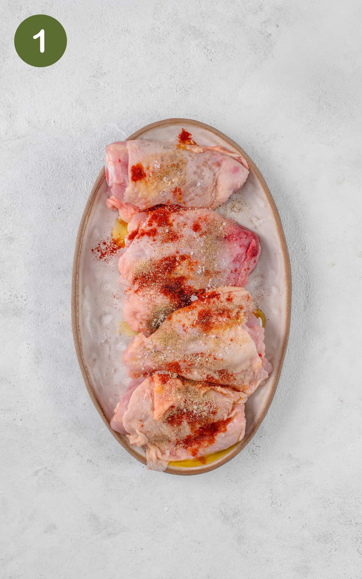 Chicken thighs with spices in a baking tray.