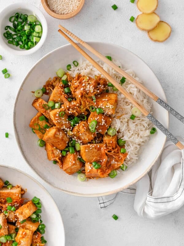 Korean crispy tofu and cabbage bowl served with rice, spring onions and sesame seeds