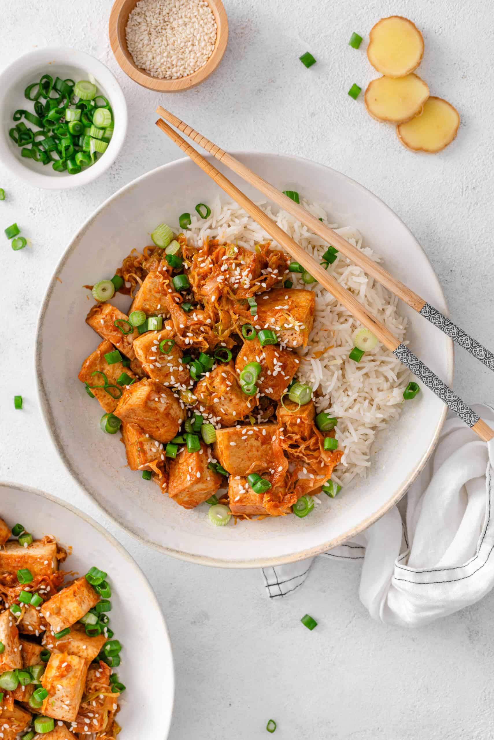 Korean crispy tofu and cabbage bowl served with rice, spring onions and sesame seeds