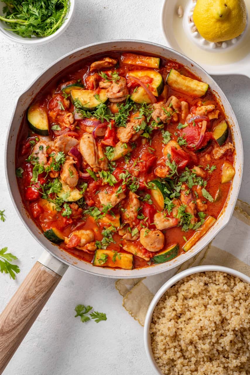 One-Pot Harissa Chicken with Courgette & Tomatoes served in a pan with quinoa